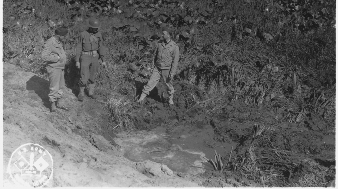 Soldiers inspect a crater caused by the Japanese attack at Fort Stevens.