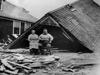 A couple sitting amongst the remains of their home at Highland Park, Rhode Island. (Credit: Getty Images)