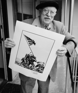 Photographer Joe Rosenthal poses with his Pulitzer Prize-winning photograph of U.S. Marines raising the flag on Mount Suribachi, Iwo Jima. (Credit: David Hume Kennerly/Getty Images)