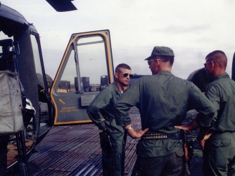 U.S. Army Maj. Charles Kettles (left), standing beside his heavily damaged “Huey” helicopter on return from the May 15, 1967 emergency extraction rescue operation. (Credit: Retired U.S. Army Lt. Col. Charles Kettles)