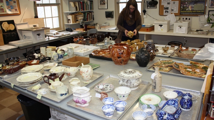 An archaeologist examines the relics from the excavation. (Credit: Sarah Jane Ruch/Museum of the American Revolution)