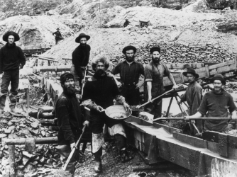 Miners display a large gold nugget during the Klondike Gold Rush.