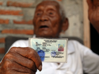 An Indonesian man, named Mbah Gotho, claimed to be 146 years old, is the oldest human in world's history shows his identity card to press members at his family house in Sragen, Central Java, Indonesia. (Credit: Anadolu Agency / Getty Images) (Photo by Dasril Roszandi/Anadolu Agency/Getty Images)