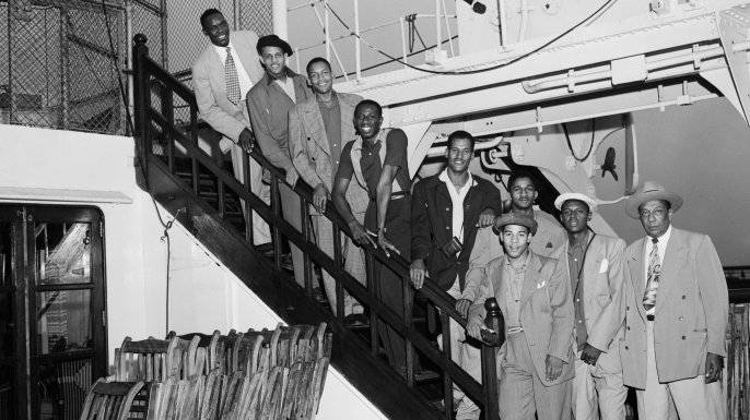 Members of the Globetrotters basketball team are shown arriving in New York aboard the liner Mauretania. From top to bottom are: Louis Pressly; William "Rookie" Brown; Boyd Buie; Reece "Goose" Tatum; Frank Washington; Markus Haynes; Sammy Quee; Clarence Wilson; and (in front) manager Winfield Welch. (Credit: Bettmann / Contributor)