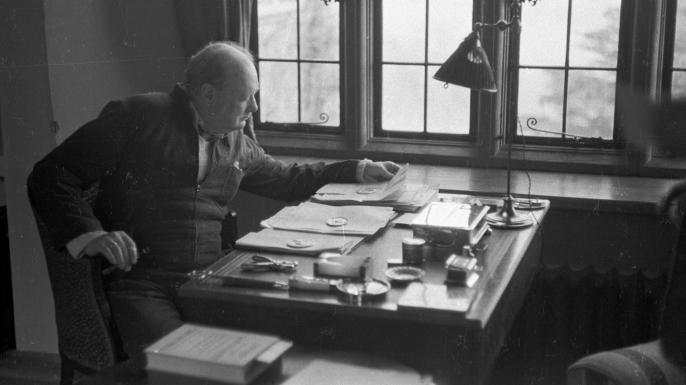 Churchill sits at the writing desk of his country home in 1939.