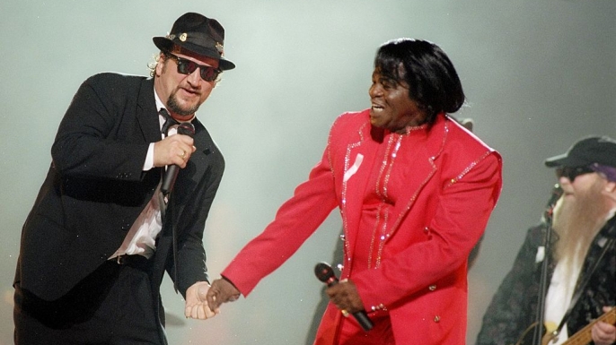 Jim Belushi and James Brown perform during the halftime show for Super Bowl XXXI.