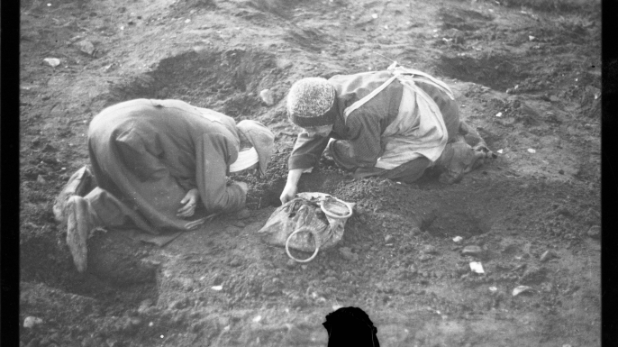 Elderly residents digging for food in the ground, 1940-1944.
