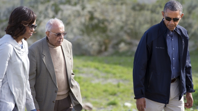 US President Barack Obama and First Lady Michelle Obama listen to former prisoner Ahmed Kathrada as they tour the limestone quarry where prisoners worked on Robben Island. (Credit: SAUL LOEB/AFP/Getty Images)