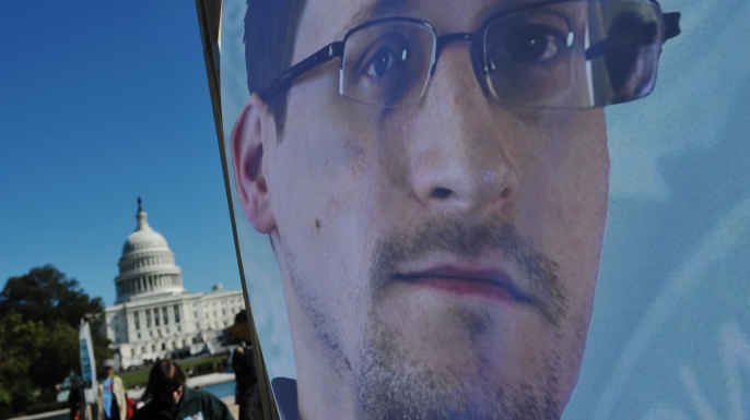 An image of Edward Snowden on the back of a banner during a protest against government surveillance on October 26, 2013. (Credit: MANDEL NGAN/AFP/Getty Images)