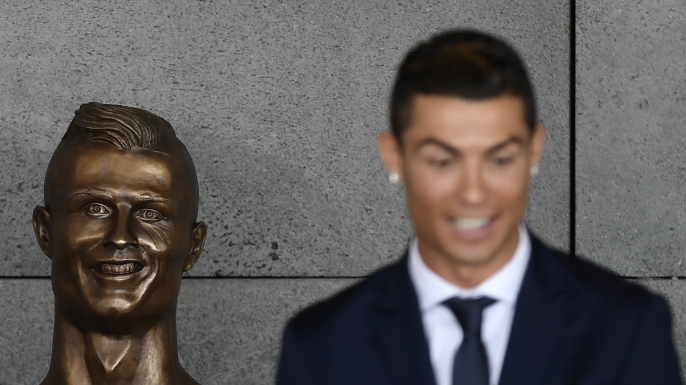 Portuguese footballer Cristiano Ronaldo stands beside a bust presented during a ceremony to rename Madeira's airport in Funchal. (Credit: FRANCISCO LEONG/AFP/Getty Images)