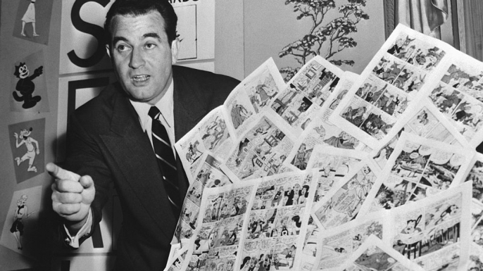 Charles F. Murphy, Code Administrator of the Comics Magazine Association of America, holding a group of "approved" comic books in 1954.