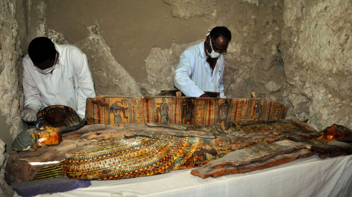 Members of an Egyptian archaeological team work on a wooden coffin discovered in a 3,500-year-old tomb in the Draa Abul Nagaa necropolis. (Credit: STRINGER/AFP/Getty Images)
