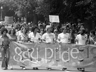 View of the large crowd, some of whom are holding up handmade signs and banners, participating in a gay and lesbian pride parade in the Back Bay neighborhood of Boston. (Credit: Spencer Grant/Getty Images)