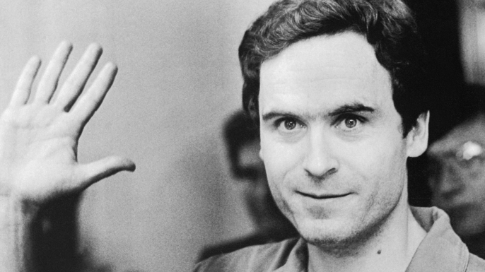Serial Murderer Theodore "Ted" Bundy walks forward and waves to TV camera as his indictment for the January murders of Lisa Levy and Margaret Bowman is read at the Leon County Jail. (Credit: Bettmann/Getty Images)