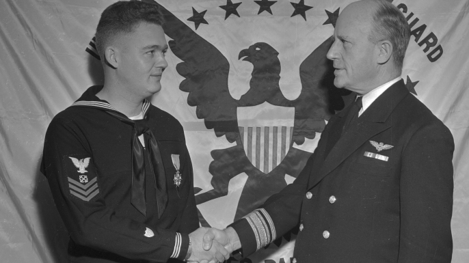 Coast Guard officer John C. Cullen receives the congratulations of Rear Admiral Stanley V. Parker in recognition of his service. (Credit: Bettmann/Getty Images)