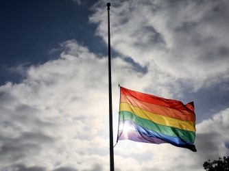 A pride flag stands a half mast during a memorial service in San Diego, California on June 12, 2016, for the victims of the Orlando Nightclub shooting. (Credit: SANDY HUFFAKER/AFP/Getty Images)