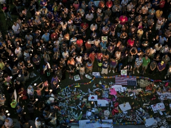 Mourners hold candles while observing a moment of silence during a vigil outside the Dr. Phillips Center for the Performing Arts for the mass shooting victims at the Pulse nightclub June 13, 2016 in Orlando, Florida. (Credit: BRENDAN SMIALOWSKI/AFP/Getty Images)