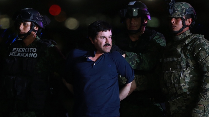 Joaquin "El Chapo" Guzman, the world's most wanted-drug trafficker, center, is escorted by Mexican security forces at a Navy hangar in Mexico City, Mexico, on Friday, Jan. 8, 2016. (Credit: Susana Gonzalez/Bloomberg via Getty Images)