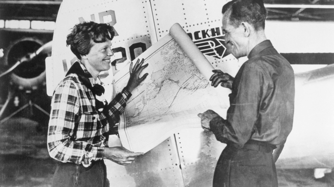 Pilot Amelia Earhart and her navigator, Fred Noonan, with a map of the Pacific that shows the planned route of their last flight. (Credit: Bettmann/Getty Images)
