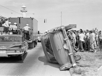 White men overturned this car belonging to black demonstrators during their arrest in Biloxi, Mississippi in June of 1963 while attempting to desegregate the Gulf Coast beach. Sixty-five people of both races were arrested in the attempt. (Credit: AP Photo/Jim Bourdier)