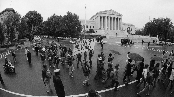 Demonstrators opposing the Allan Bakke "reverse discrimination" case pass the Supreme Court in Washington,1977. (Credit: Charles Tasnadi/AP Photo)