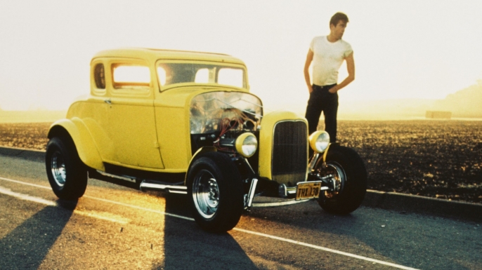 Actor Paul Le Mat, standing beside a Ford Model B five-window coupe, also known as the Deuce Coupe, in a publicity still for the film American Graffiti. (Credit: Silver Screen Collection/Getty Images)