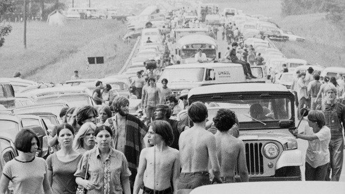 Crowds walk along roads choked with traffic on the way to Woodstock. (Credit: Hulton Archive/Getty Images)