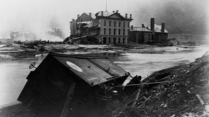 A wrecked freight car next to twisted railroad tracks, after the Johnstown, Pennsylvania flood of 1889. The warehouse of the Cambria Iron Works Company in the back was severely damaged. (Credit: Library of Congress/Corbis/VCG via Getty Images)