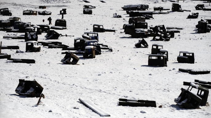 Afghan men walk amongst the remains of Russian military vehicles on the outskirts of Kabul on February 14, 2009 on the eve of the 20th anniversary of the withdrawal of Soviet troops from Afghanistan. Soviet troops withdrew from Afghanistan on February 15, 1989, after ten years of fighting against Mujahiddin millitamen. (Credit: Massoud Hossaini/AFP/Getty Images)