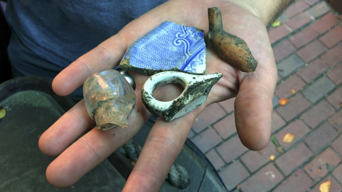 Boston city archaeologist Joe Bagley displays fragments of pottery and a tobacco pipe recovered from a site that experts believe may have contained an outhouse used by Paul Revere, September 28, 2017. (Credit: William J. Kole/AP Photo)