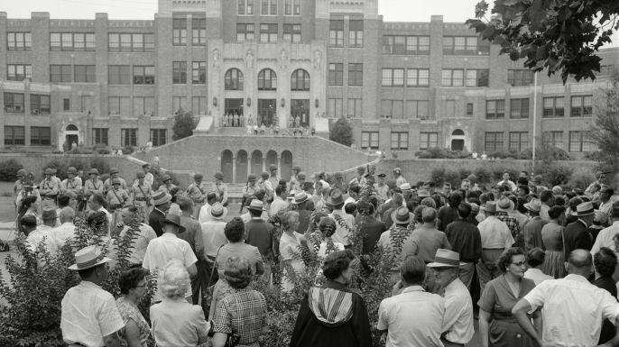 The crowd gathered outside Little Rock Central High School. The military men were ordered by Governor Orval Faubus to surround the school and prevent Black students from entering the grounds. (Credit: William P Straeter/AP/REX/Shutterstock)
