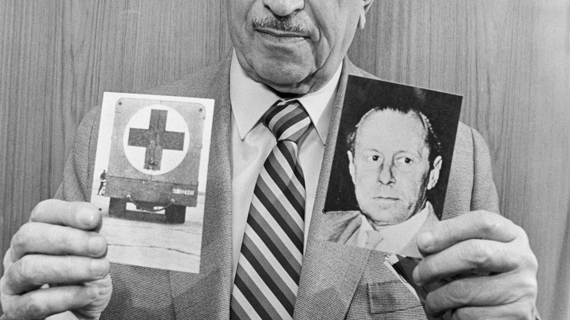 Nazi hunter Simon Wiesenthal holding photographs depicting former Gestapo chief Walter Rauff and a mobile gas-chamber van he created to execute Jews. Rauff was protected from prosecution by Argentine president Augusto Pinochet. (Credit: Bettmann Archive/Getty Images)