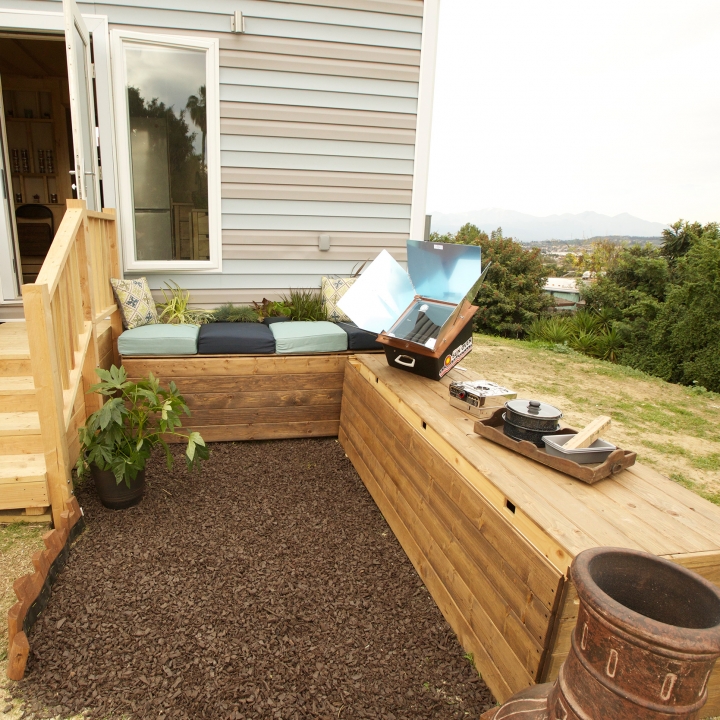 The outside area functions for comfort and utility, with 600 gallons of water that can be stored in rain benches and a solar-powered sun oven.