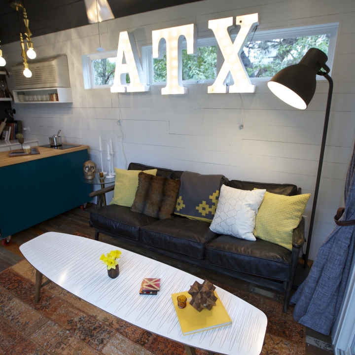 The letters A, T and X hang above the couch in the home of these proud tiny house Texans.