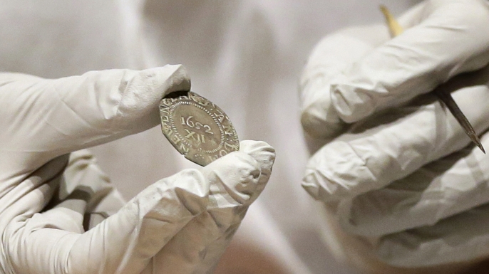 Hatchfield holding the 1652 "Pine Tree Shilling" found in the capsule