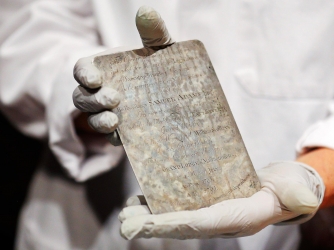 Boston MFA conservator Pam Hatchfield holding an engraved silver plate from the time capsule, which is thought to be the work of Paul Revere.