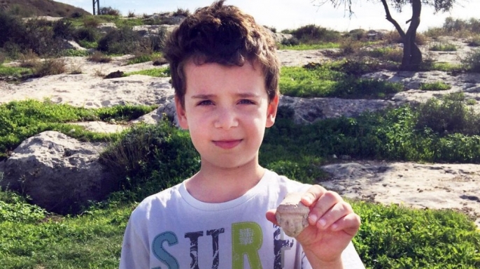 Itai with the head of the statuette he found on Tel Beit Shemesh. (Credit: Courtesy Israel Antiquities Authority/the Ministry of Foreign Affairs)
