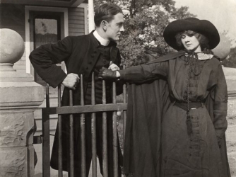 Owen Moore talks to Florence Lawrence in a scene still from a silent drama.