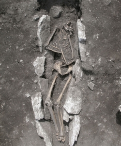 Human buried in the middle of the ash altar with covering plates in the pelvic area.