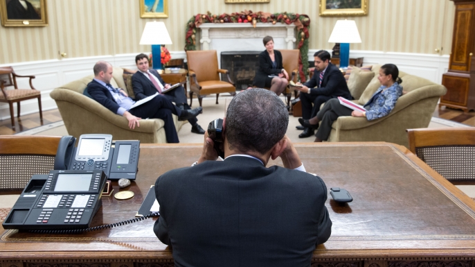 President Barack Obama talks on the phone during a National Security Council (NSC) call in the Oval Office, Dec. 16, 2014. (Official White House Photo by Pete Souza)