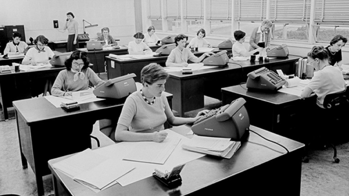 Macie Roberts' computing group circa 1955 (far right). Barbara Paulson is on the telephone (standing, back left). Helen Ling is at the second desk in the left row. (Credit: JPL)