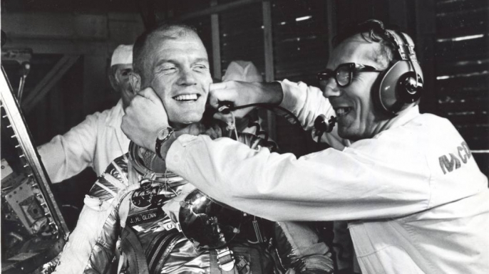 Guenter Wendt, the original pad leader for NASA's manned programs, coaxes a smile from Glenn after a postponement of the mission. (Credit: NASA)