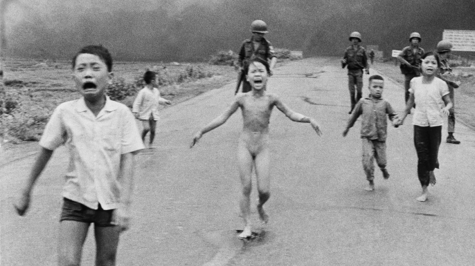 South Vietnamese forces follow after terrified children, including 9-year-old Phan Thi Kim Phuc, center, as they run down Route 1 near Trang Bang after an aerial napalm attack on suspected Viet Cong hiding places.