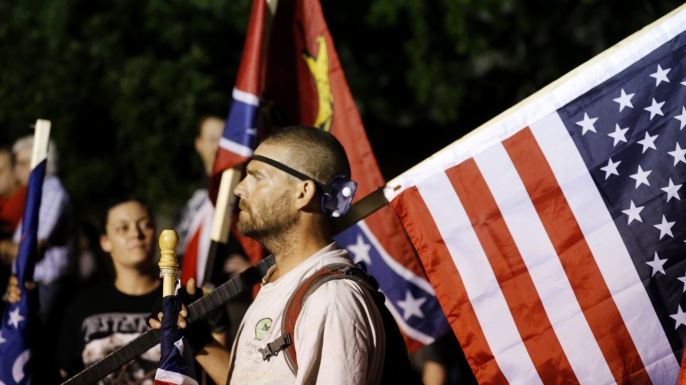 A demonstrator who supports keeping Confederate era monuments joins other protestors before the Jefferson Davis statue was taken down in New Orleans, Thursday, May 11, 2017. (AP Photo/Gerald Herbert)