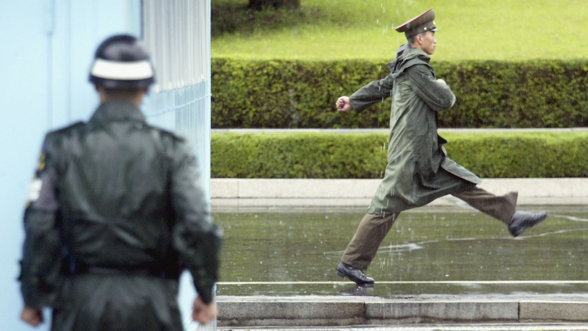 A South Korean soldier (L) looks at a North Korean soldier as he marches past at the truce village of Panmunjom in the demilitarized zone (DMZ) between South and North Korea. (Credit: Chung Sung-Jun/Getty Images)
