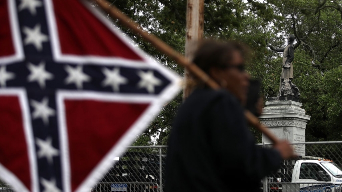 A protester holds a Confederate flag across the street from the Jefferson Davis monument on May 4, 2017.