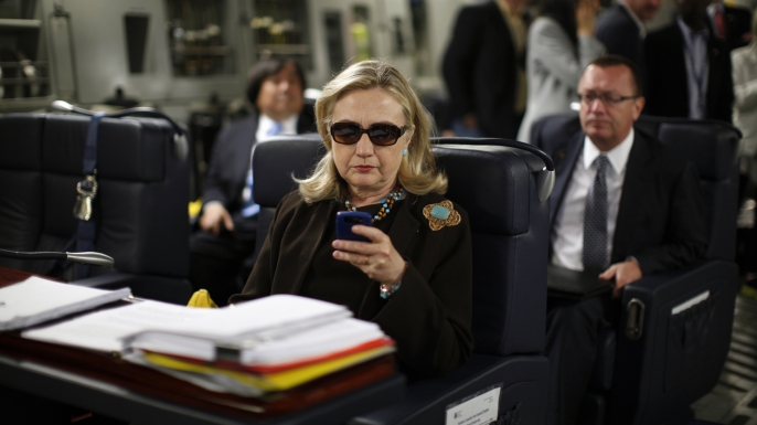 Then-Secretary of State Hillary Rodham Clinton checks her Blackberry from a desk inside a C-17 military plane upon her departure from Malta, in the Mediterranean Sea, bound for Tripoli, Libya. (Credit: AP Photo/Kevin Lamarque, Pool, File)