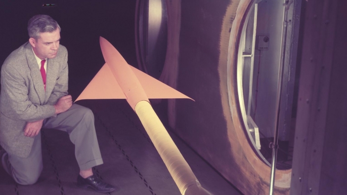 NACA member Charles Hall studies a model aircraft.