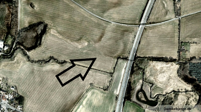 Satellite photo with added hill shade, revealing the circular formation discovered, pointed out by the arrow. (Credit: Danskebjerge/Wikimedia Commons/CC BY-SA 3.0)