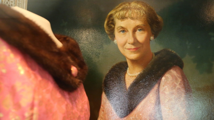 An oil painting of Mamie Eisenhower hangs beside the fur collared gown she wore for the portrait, at the Eisenhower Library in Abeline, Kansas. (Credit: Bo Rader/Wichita Eagle/TNS via Getty Images)